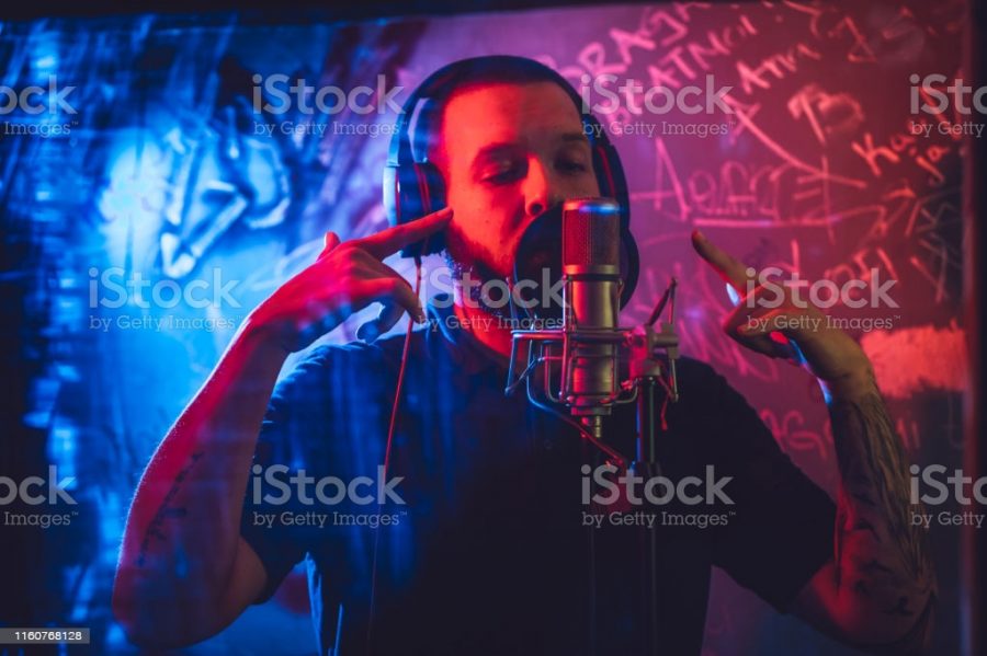 Young caucasian male rap musician singing in studio in deaf room.