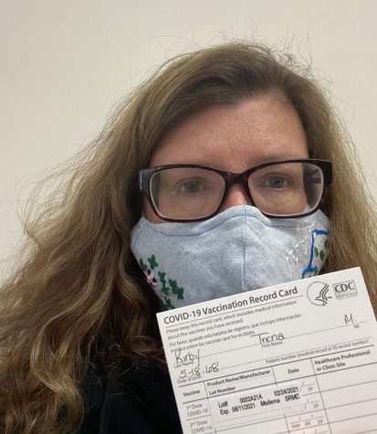 Trena Kirby, AP Human Geography and AP Government & Politics teacher at Athens Drive wears a mask and poses with her vaccination card for receiving the Moderna vaccine.
