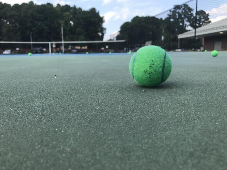 Several tennis balls are scattered throughout the court as the Women’s varsity tennis team concludes practice.