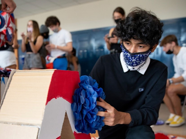 Sophmore Saeed Siddiqi puts together a cardboard A for America Monday’s photo booth for the fall homecoming spirit week.