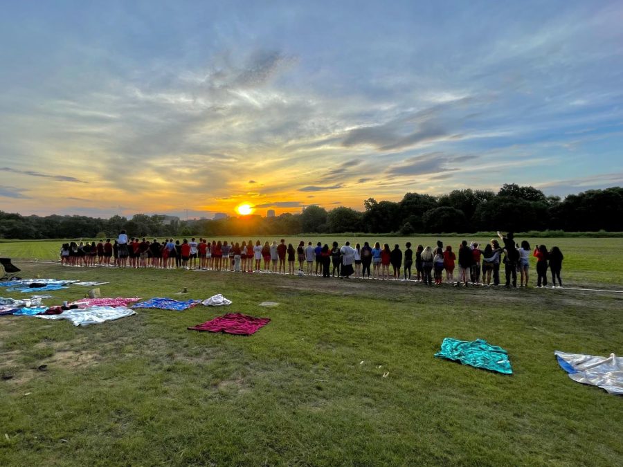 Seniors present at the senior sunrise pose facing the sun at Dorothea Dix park. Seniors participating in the unofficial school event arrived decked out in college gear on the last Friday before test week to create some final lasting memories.