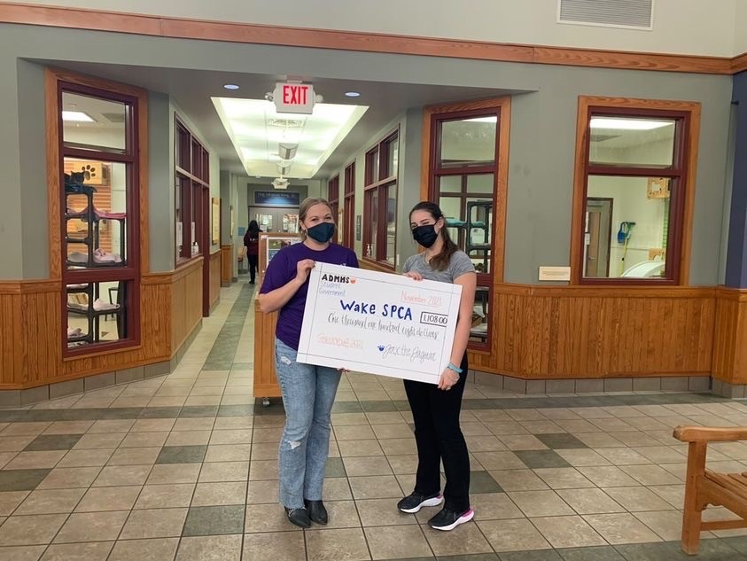 Zoe Politis (right) holding the Society for the Prevention of Cruelty of Animals check given by Athens Drive High School from the funds of Powderpuff.