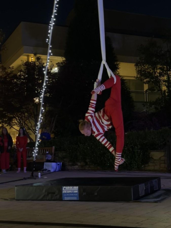 An aerial acrobat doing spins on a silk rope at the Waverly Place Christmas tree lighting. 