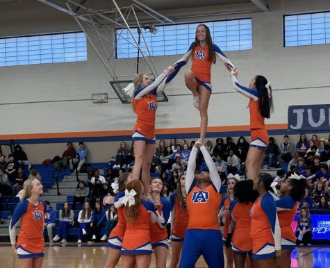 The Athens Drive cheerleaders are stunting to hype students up. 
