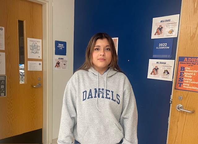 Janet Alcantara (pictured) in the hallway at Athens Drive High School. Alcantara translates for a student (not pictured), creating a sense of community for the student.