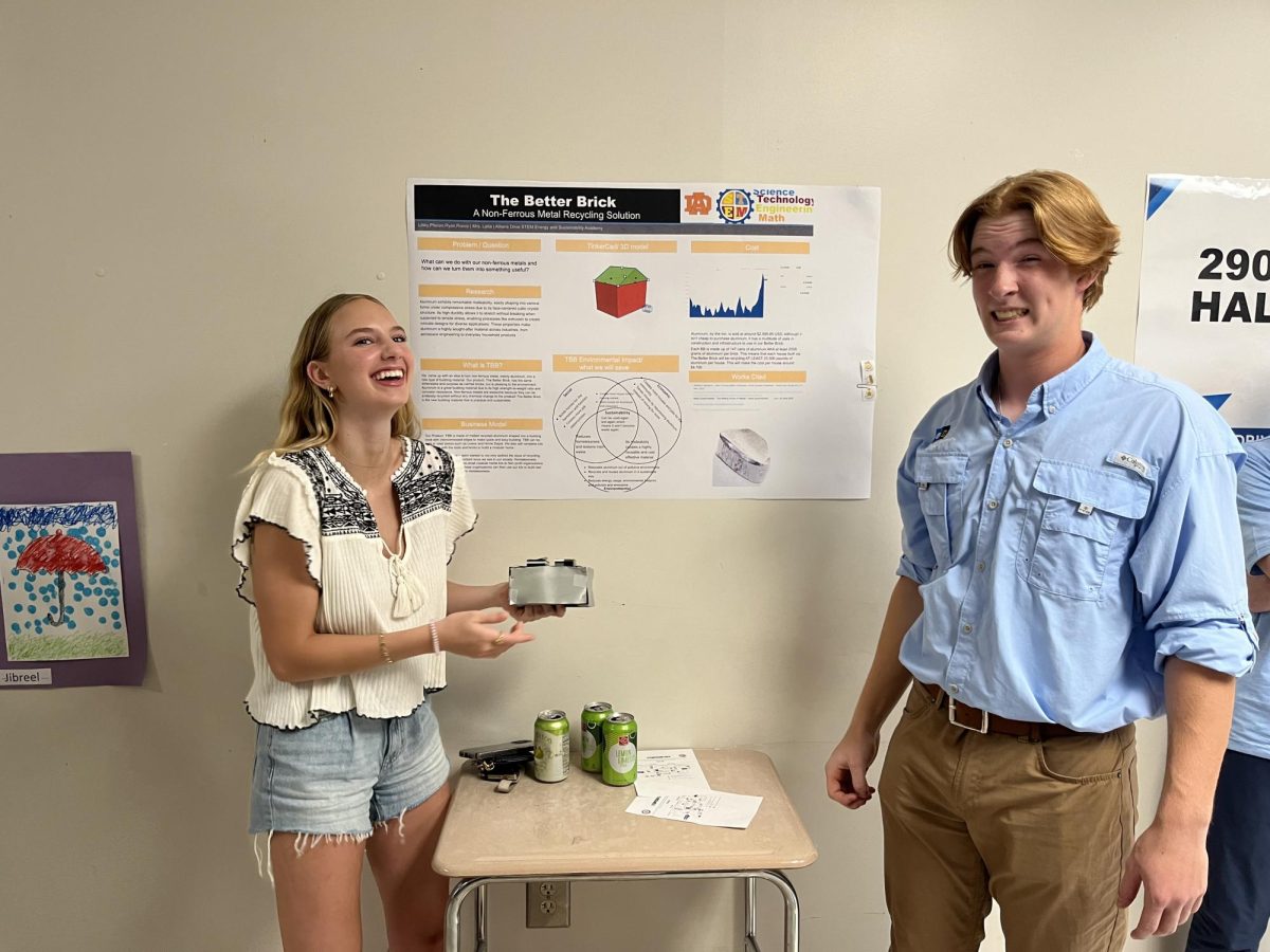 Libby OLeary (left) and Ryan Bartley (right) laugh as they present their project. The sophomore projects were centered around resdesigning the recycling process through new consumer practices.
