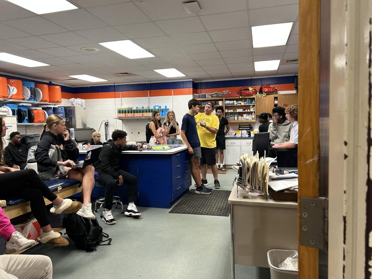 Philips and his sports medicine class where he is showing them how to do a wrap. This is part of the education on injuries and how to treat them.