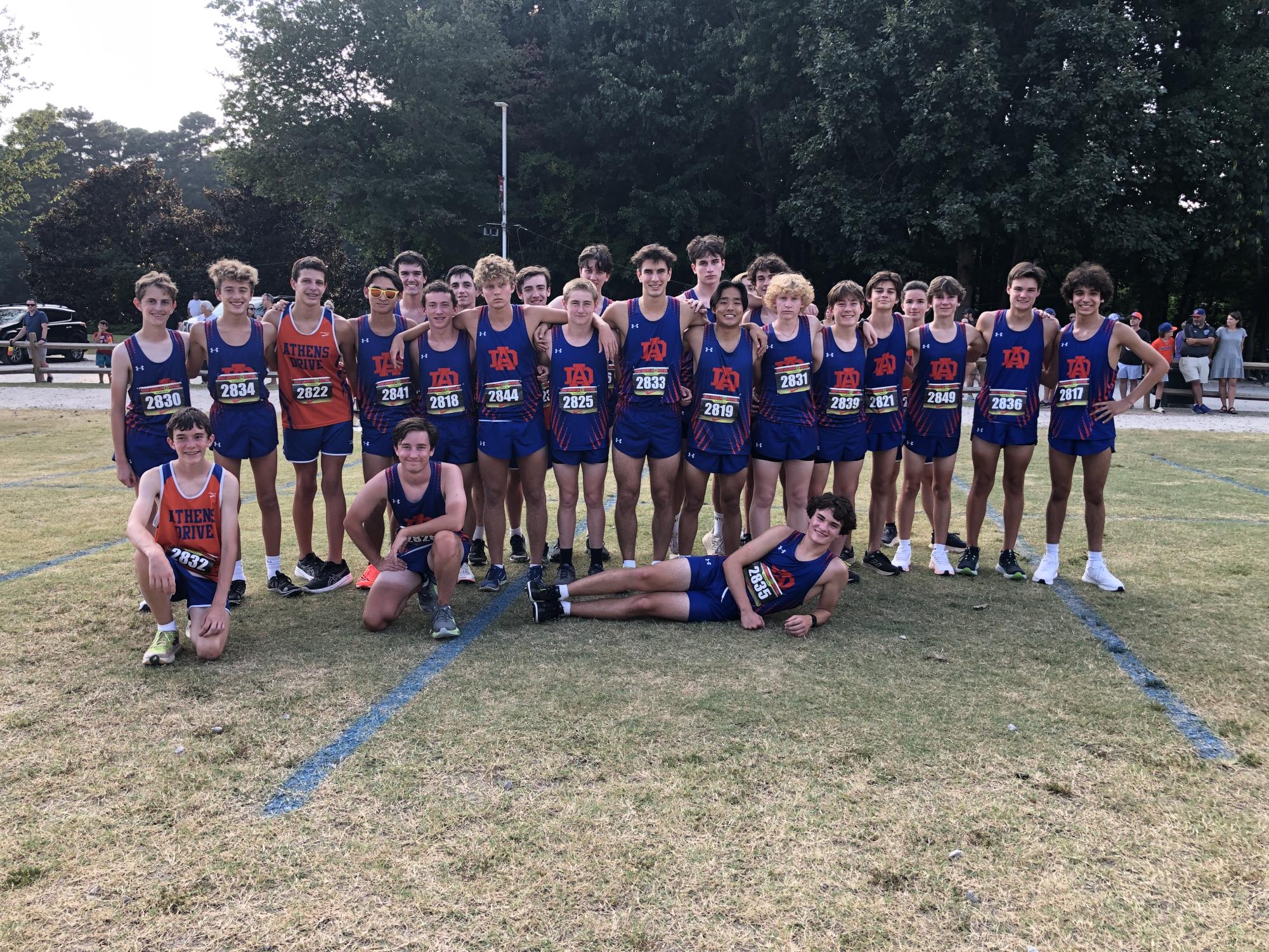 The cross country boys team posing for a picture at a team meet. Cross Country is a sport that is all about teamwork and togetherness between players and coaches and even other teams.(Photo credits by Lori Lair).
