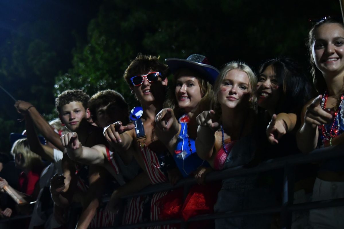 Seniors dressed up on theme for one of the home football games display their school spirit, front and center in the stands. 