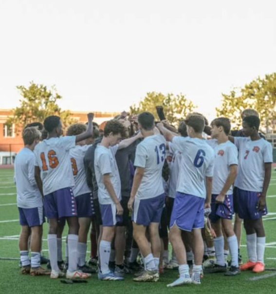 Athens Drive team in a huddle before a match