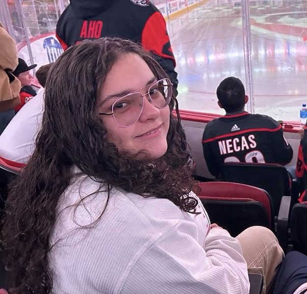 Louisara poses for a picture at a Hurricanes game. Louisara is a sophomore, who enjoys telling her story as an immigrant. 