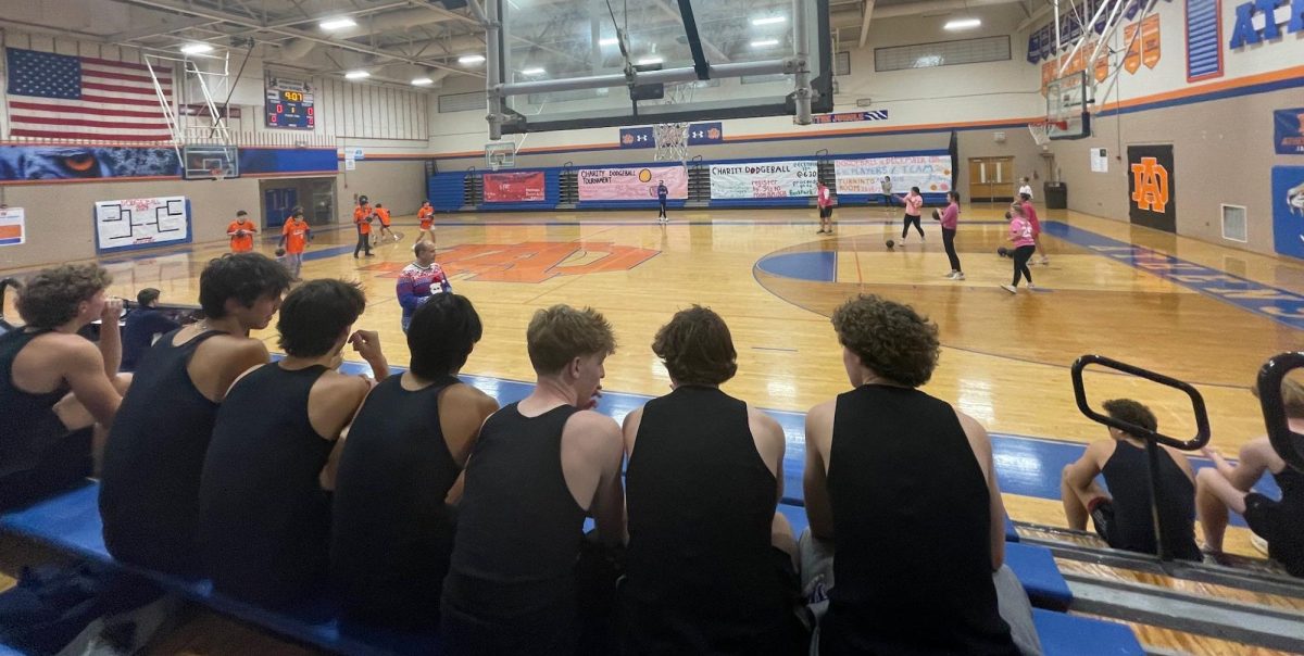 Dodgeball players sit and watch the other games as they wait for their match. There were six teams competing overall, but only one was named victor.