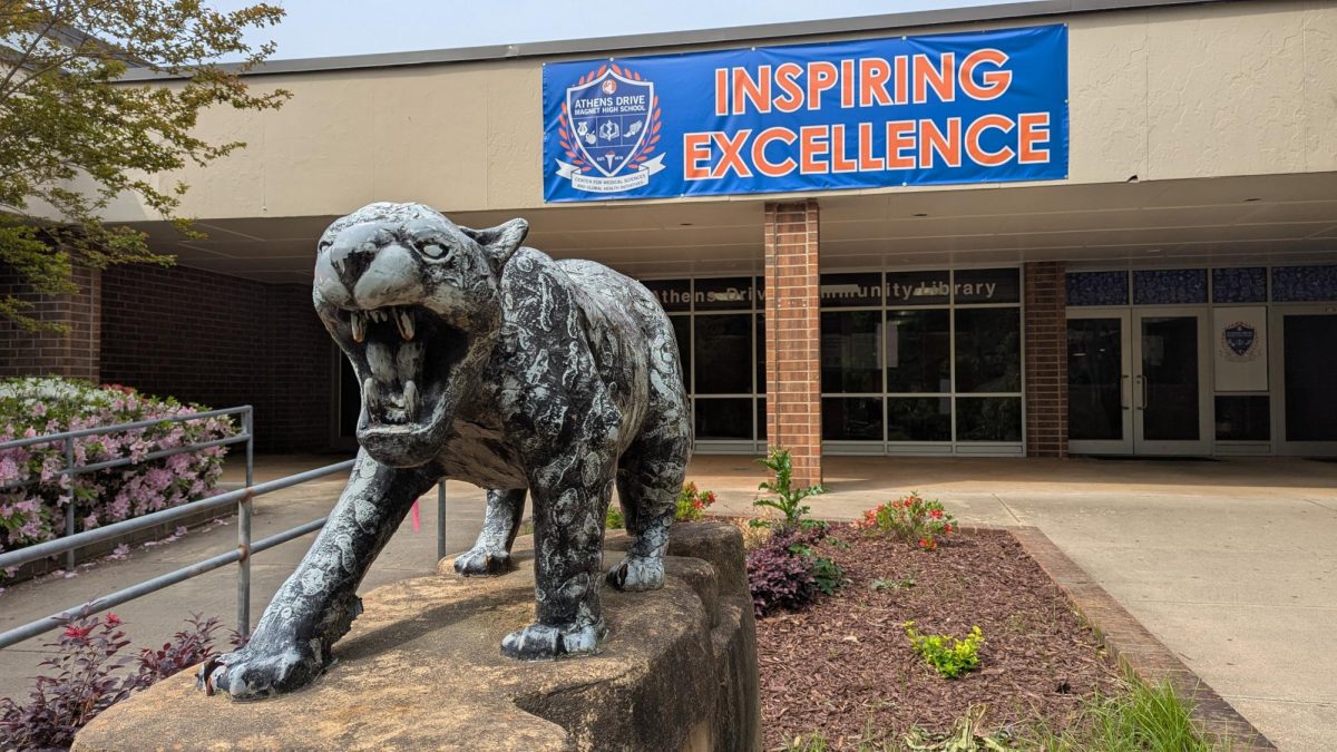 The library-side entrance to Athens Drive. A metal statue of a jaguar is in the foreground, with its teeth bared