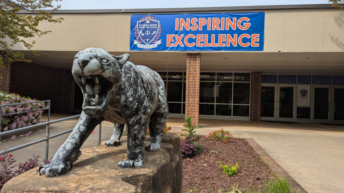 The library-side entrance to Athens Drive. A metal statue of a jaguar is in the foreground, with its teeth bared