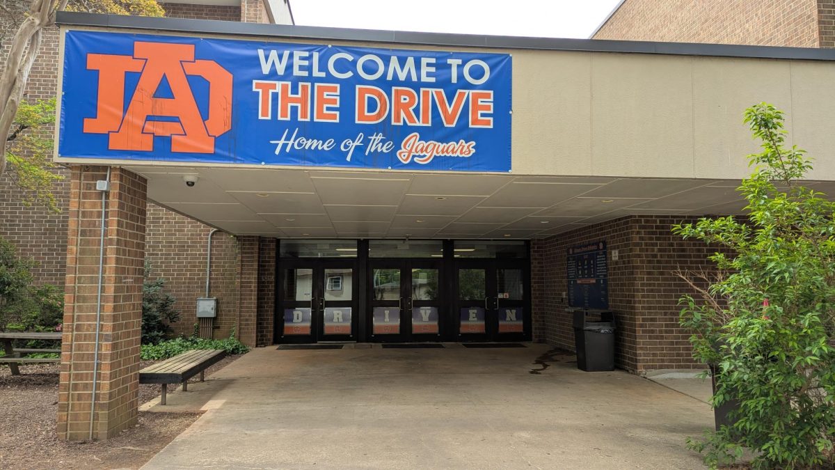 The auditorium-side entrance to Athens Drive. A banner above reads: "Welcome to the Drive, Home of the Jaguars"