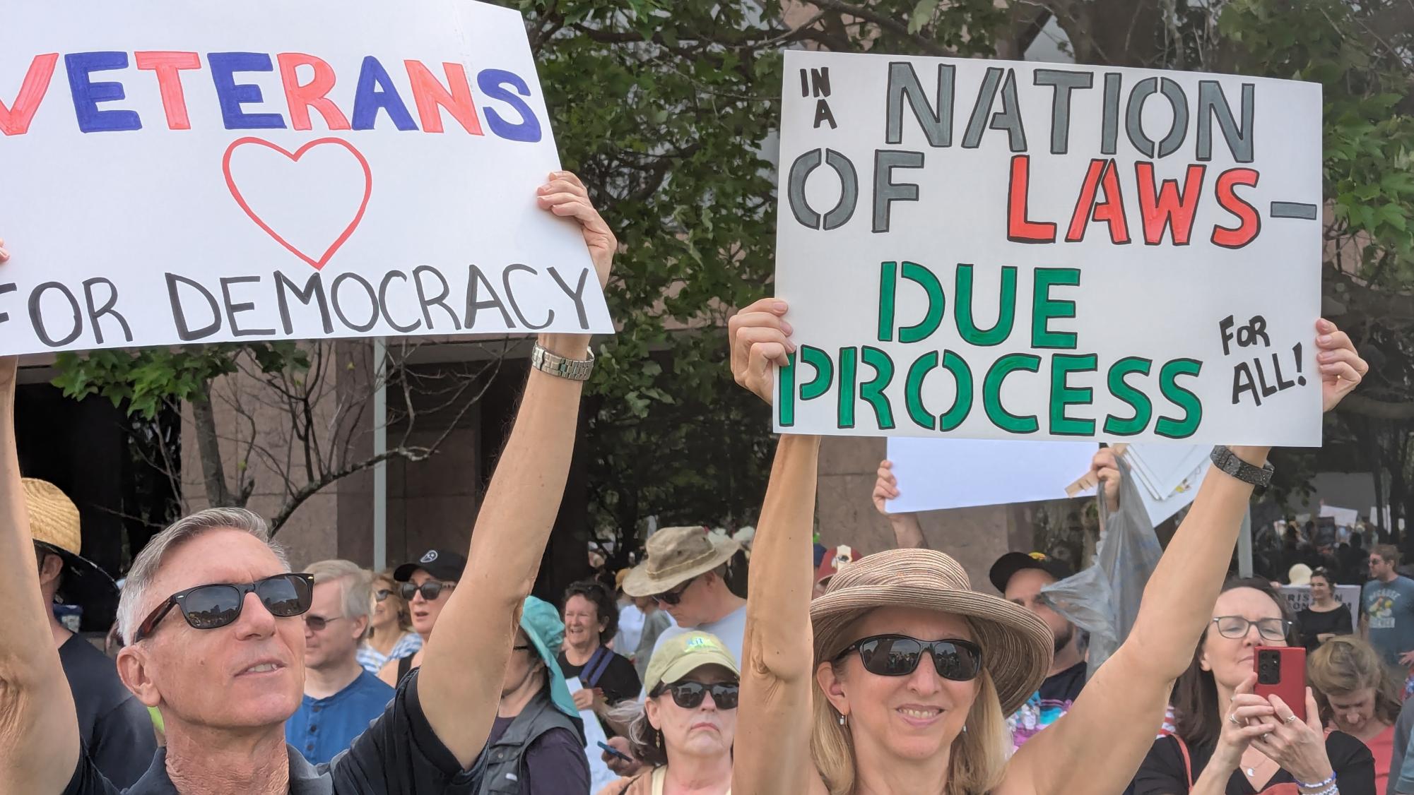 Two protesters at the Raleigh April 19th "Forward Together" anti-Trump protest. They are carrying signs reading together "veterans for democracy, in a nation of laws — due process for all"