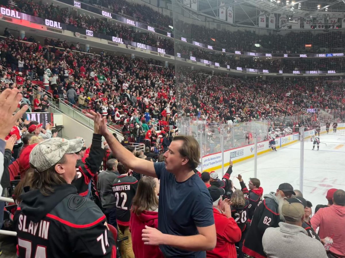 Canes fans cheer and high five after a goal by the Hurricanes against the Washington Capitals on November 11. Fans will celebrate together, giving fist bumps, high fives and cheers, often without knowing who the others are, bonding over their love for the team.