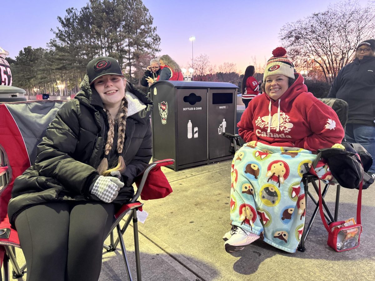 Hurricanes season ticket members, Molly Black (left) and Erin Hatfield, pose for a photo while waiting for the Lenovo Center doors to open in their camping chairs. They always make sure to be the first in line to enter the building, in order to stand by the boards for pregame warmups.