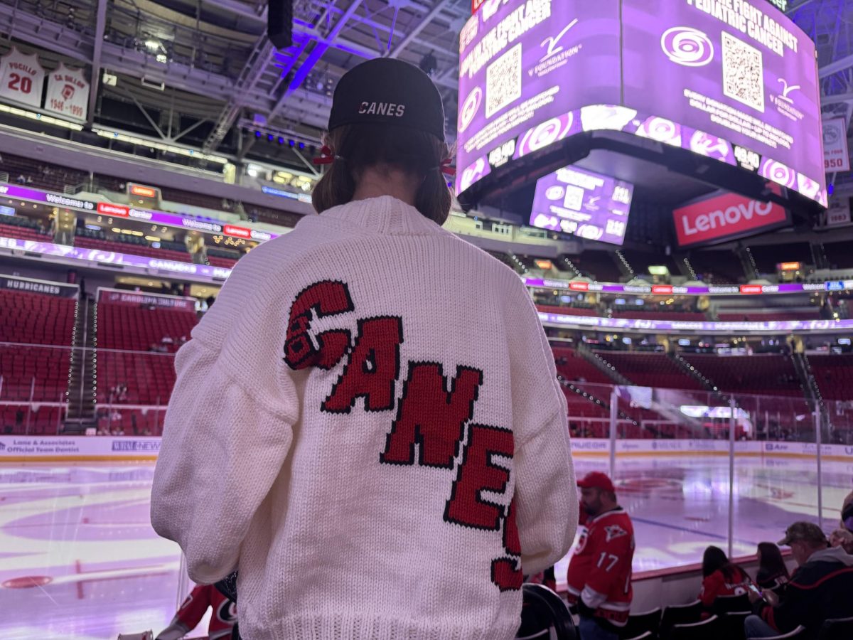 Hurricanes season ticket member, Meg M. is pictured from the back, in order to show her handmade sweater. Meg has made various different Hurricanes themed sweaters, and she even sells them on social media.