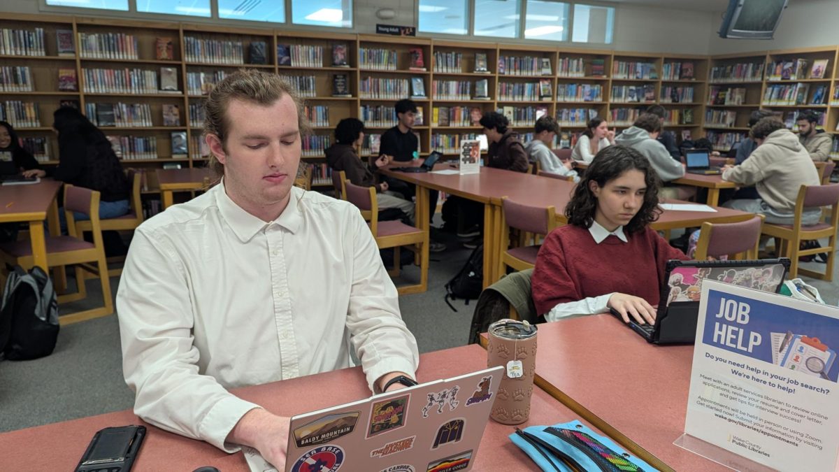 Students here are working on classwork with their computers in the . The library provided a study space for them with books, tables and chairs, and students were able to go up to librarians to ask any questions they had.