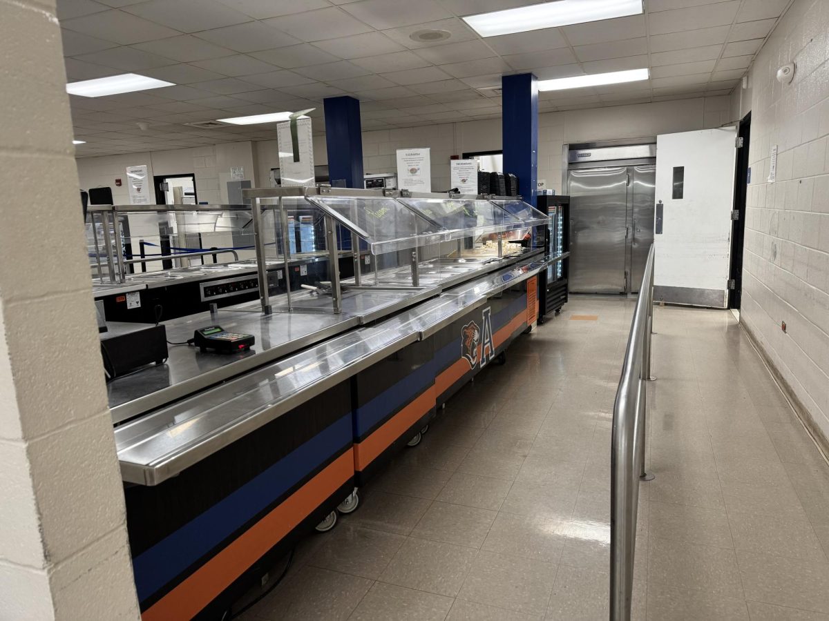 The lunch cafeteria staff is preparing the meals for students. As the lunch lines get full from the start to the end. School lunches are very beneficial for students whose outside-of-school meals are sometimes beyond their price range. 