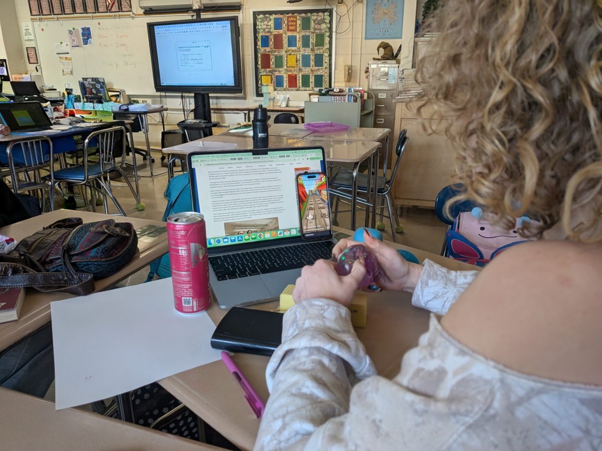 Ella Johnson senior, reading an article on the Athens Oracle. Watching Subway Surfers and playing with a NeeDoh.
