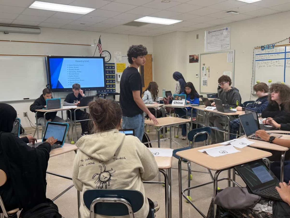 Yusuf Rahmani communicates to a member of Model UN, clarifying what needs to be done. He had previously done a presentation (as seen behind) talking about what Model UN is.
