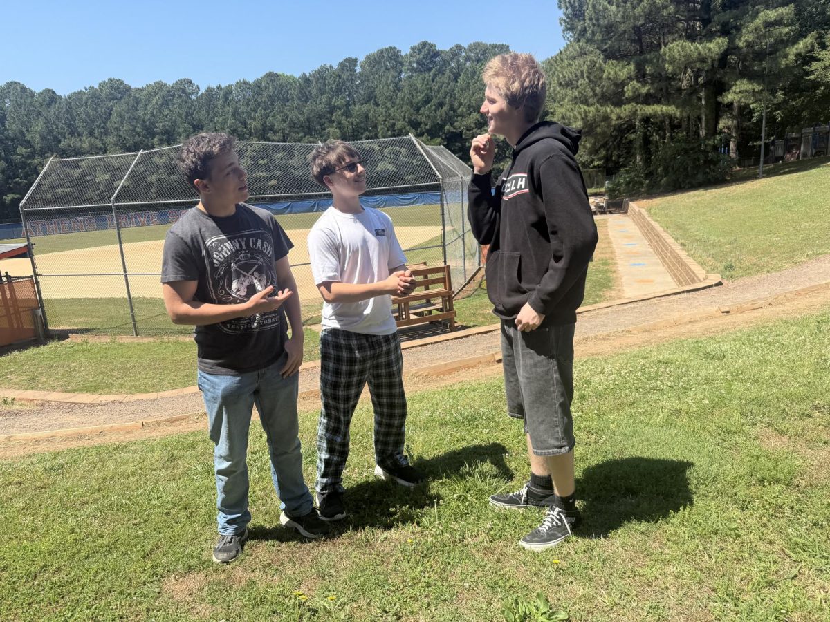 Freshmen students Logan Thompson, Conner Shultz and Weston Overman  (left to right) engage in friendly conversation. They share each other's summer plans as freshman year comes to an end.